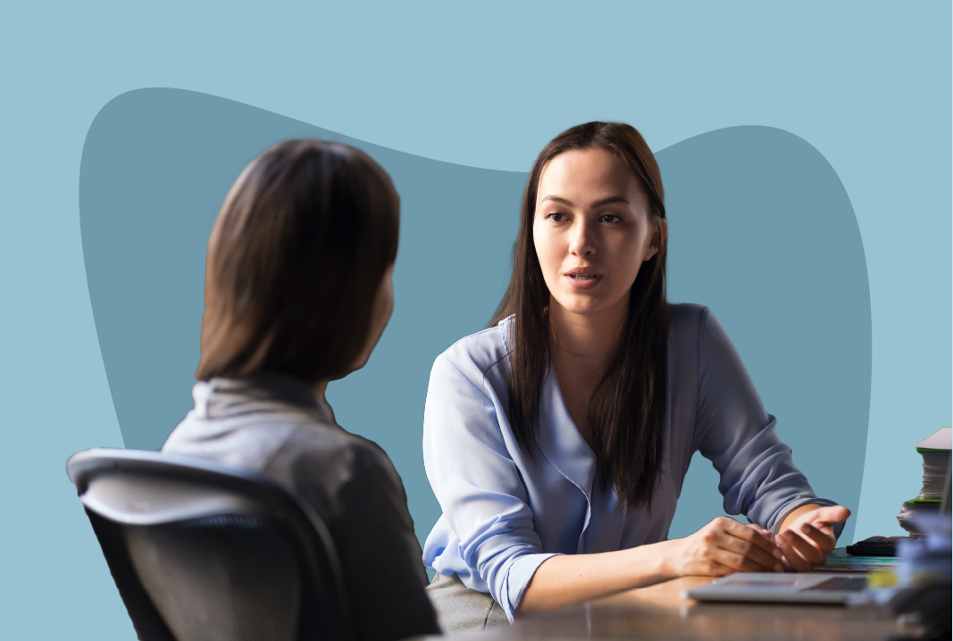 Two employees talking at a table.