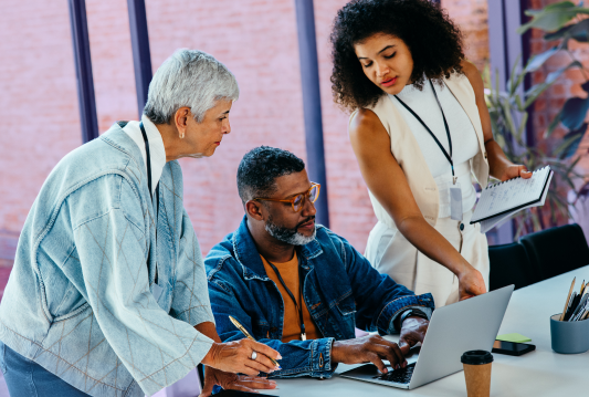 Three employees are discussing employee training courses