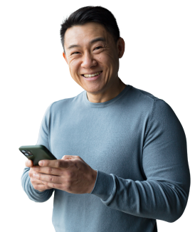 Man smiling at camera, holding a phone.