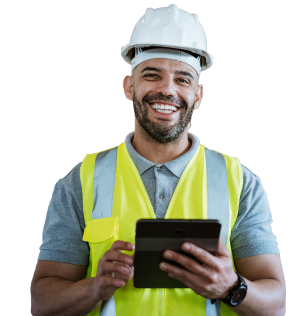 Man in construction uniform smiling at camera holding a tablet.