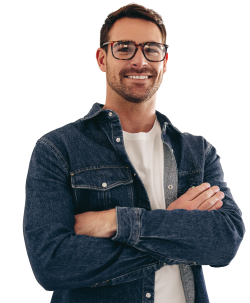 Man in casual clothes smiling at camera with his arms crossed.