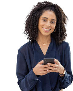 Woman smiling at camera, wearing business casual, holding a cell phone.