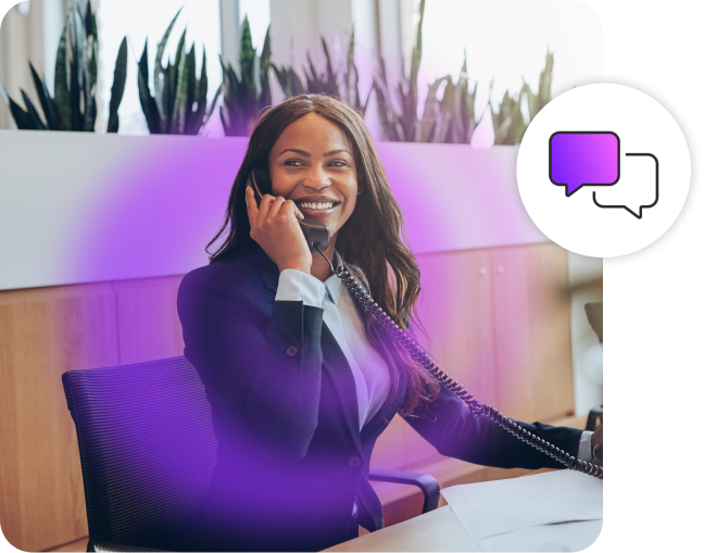 Lady smiling while on corded phone in an office.