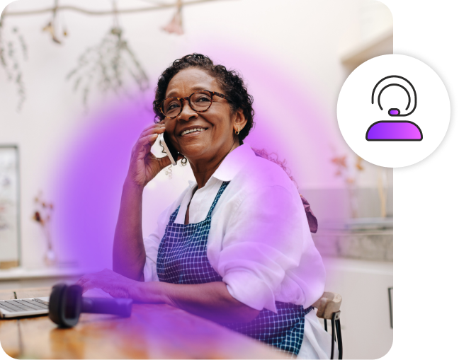 Woman smiling on phone while sitting in a flower shop.