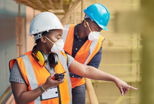 One employee is pointing out a common hazard in construction to another employee.