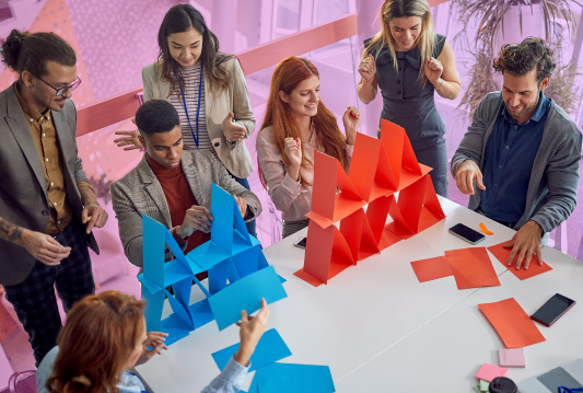 A group of employees is sitting around a table and are participating in an employee engagement activity