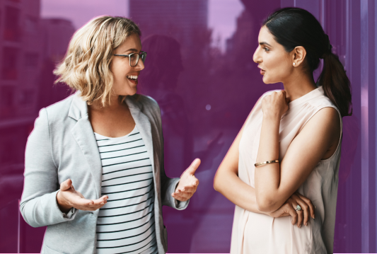 Two employees are talking to each other in a pleasant and engaging manner.